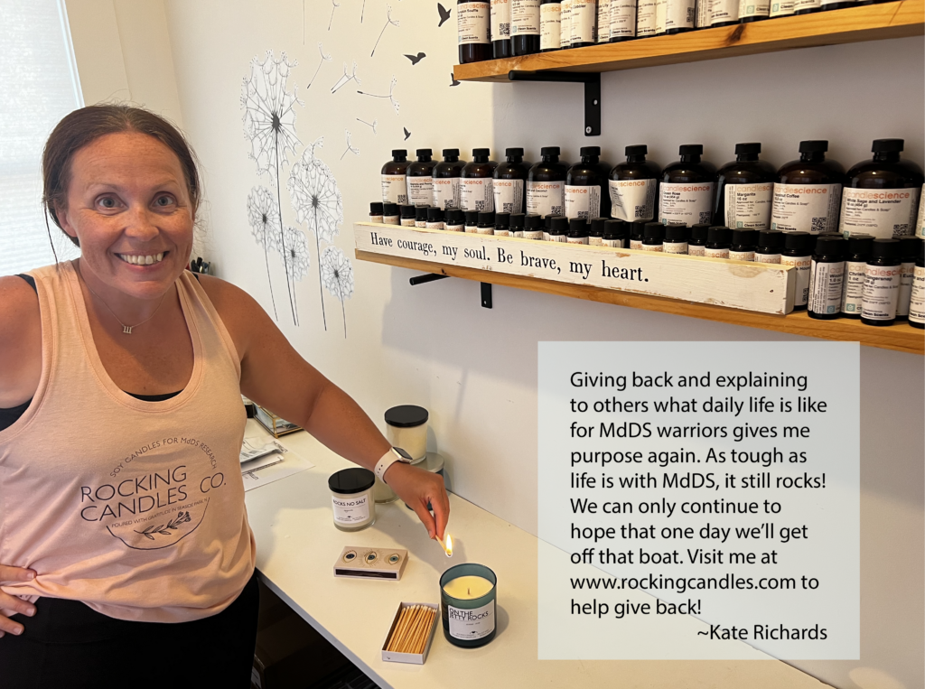 a smiling woman is lighting a candle in a candle shop